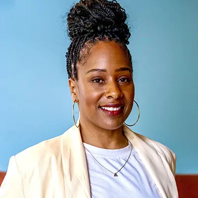 Lafonda Cousin wearing a pale yellow suit jacket and hoop earings